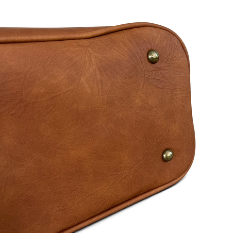 Cotton Road Handbag in brown PU leather with smooth textured finish and protective metal feet on the base