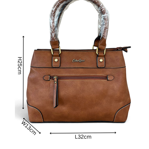Cotton Road Handbag in brown PU leather with twin handles, white stitching, and front zip pocket