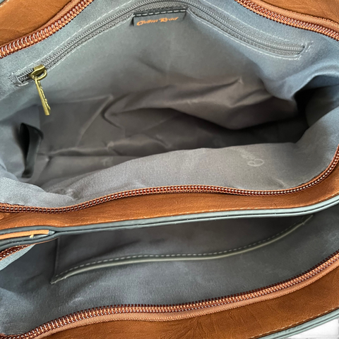 Cotton Road Handbag in brown PU leather, showing spacious zip compartments and grey fabric lining with pockets
