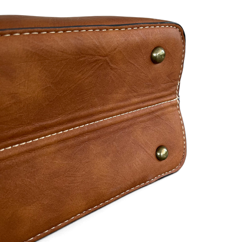Cotton Road Handbag in brown PU leather, featuring white contrast stitching and antique-look brass studs on the base