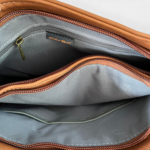 Cotton Road Sling Bag in brown PU leather, showing two spacious zip compartments and inner organiser pockets