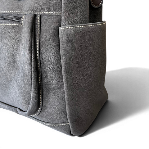 Cotton Road Handbag in khaki PU leather with top stitch and antique brass hardware, featuring multiple zip compartments and adjustable shoulder strap