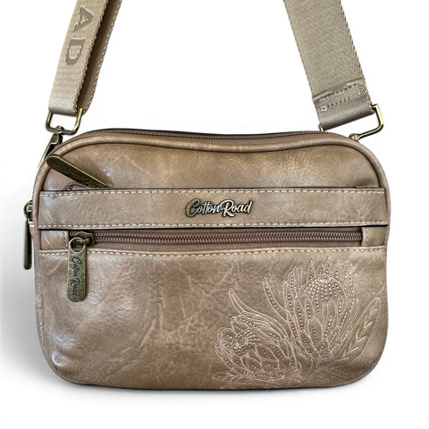 Cotton Road Sling Bag in khaki PU leather with embroidered Protea design and branded adjustable strap