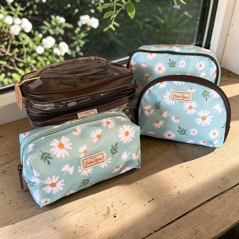 Cotton Road toiletry bag set in turquoise with white daisies and brown trim, featuring clear PVC vanity case and three zippered cosmetic bags