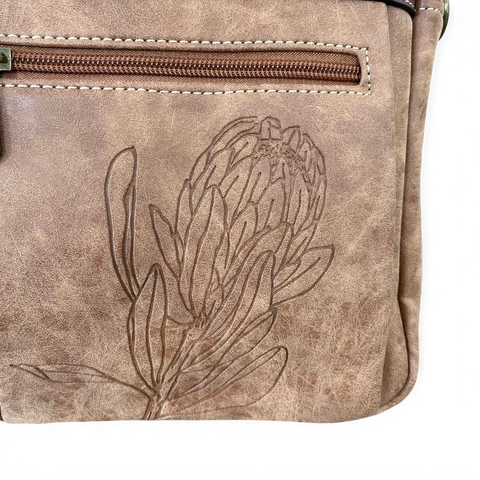 Cotton Road Laptop Bag in distressed khaki PU leather, featuring a stitched Protea design and front zip pocket